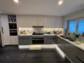 Grey and white handleless kitchen fitted in Dublin with a marble effect worktop